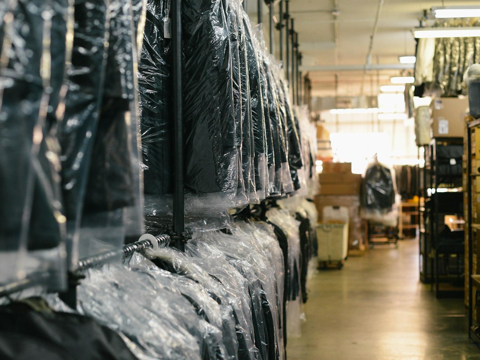 A rack of dry-cleaned garments wrapped in plastic