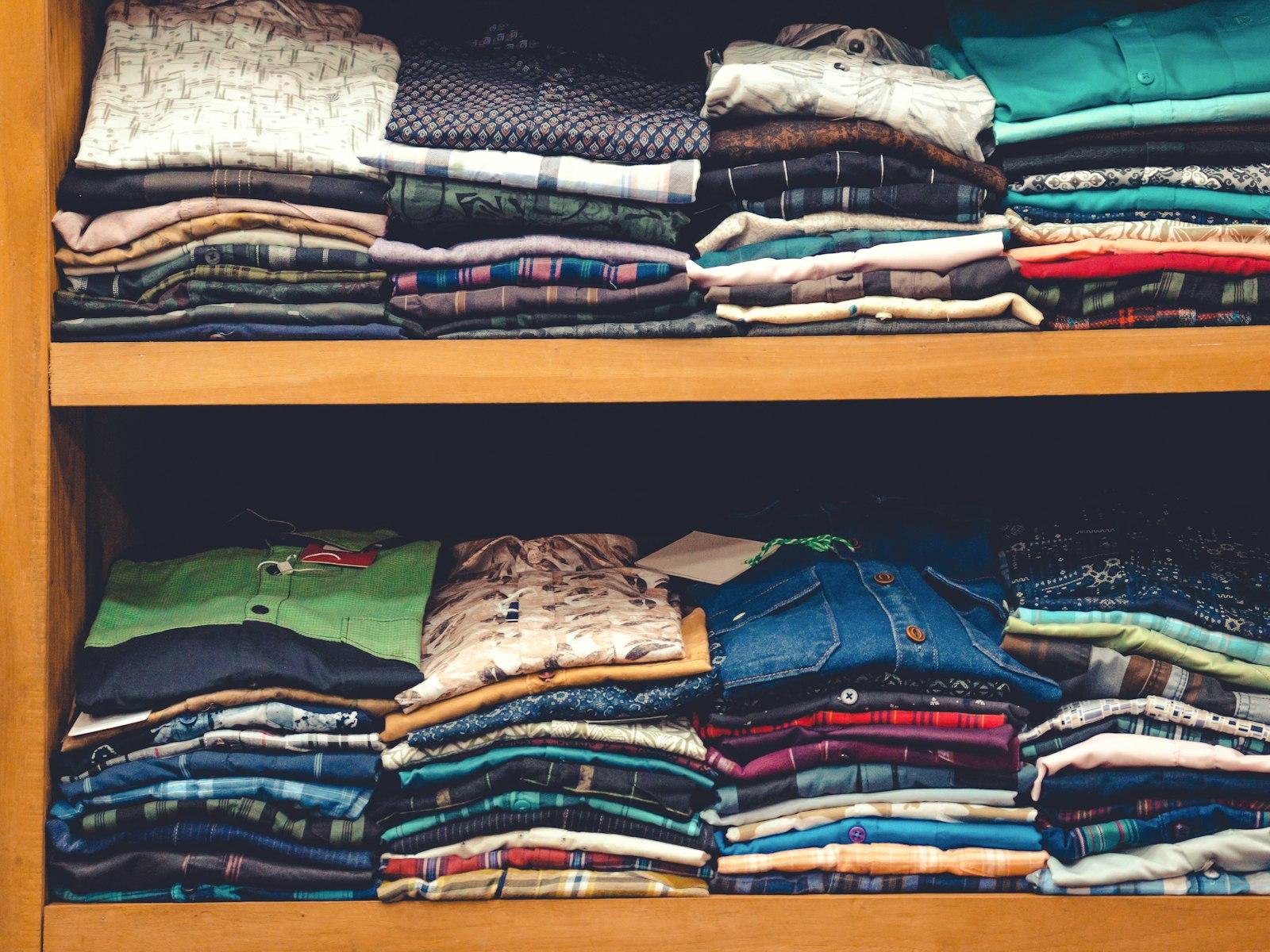 Neatly folded, colourful clothes stacked on a shelf